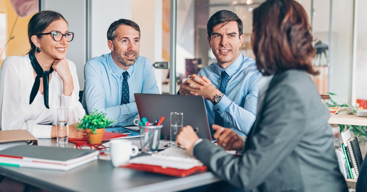 Two women and two men talking in an office