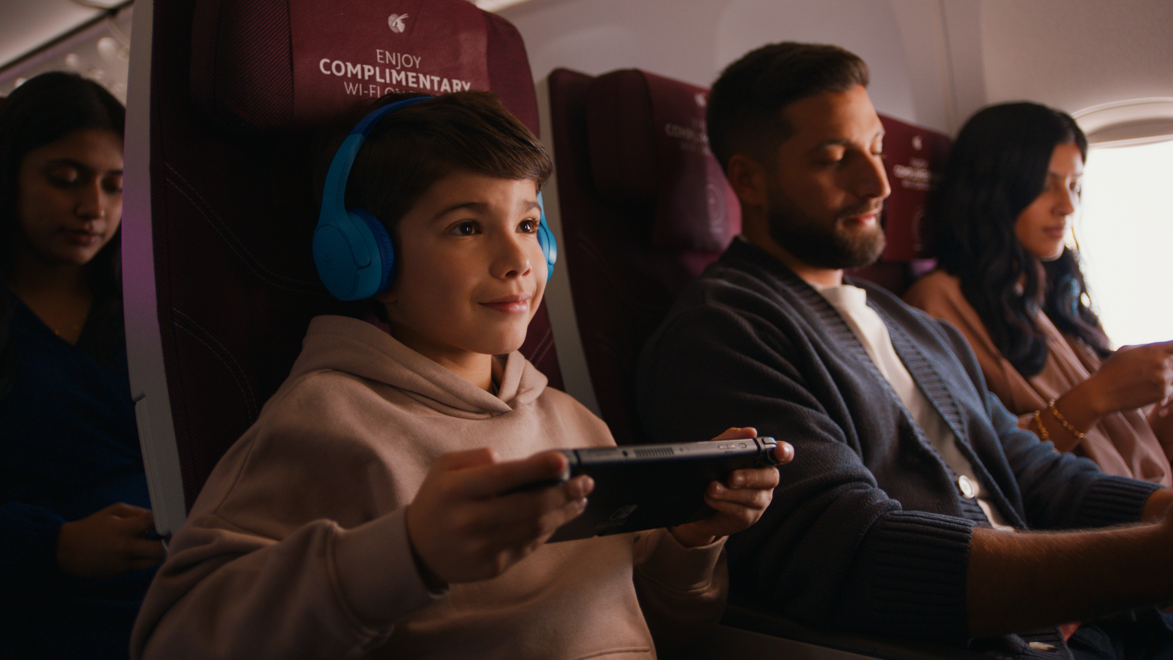 A young boy on a plane with a tablet