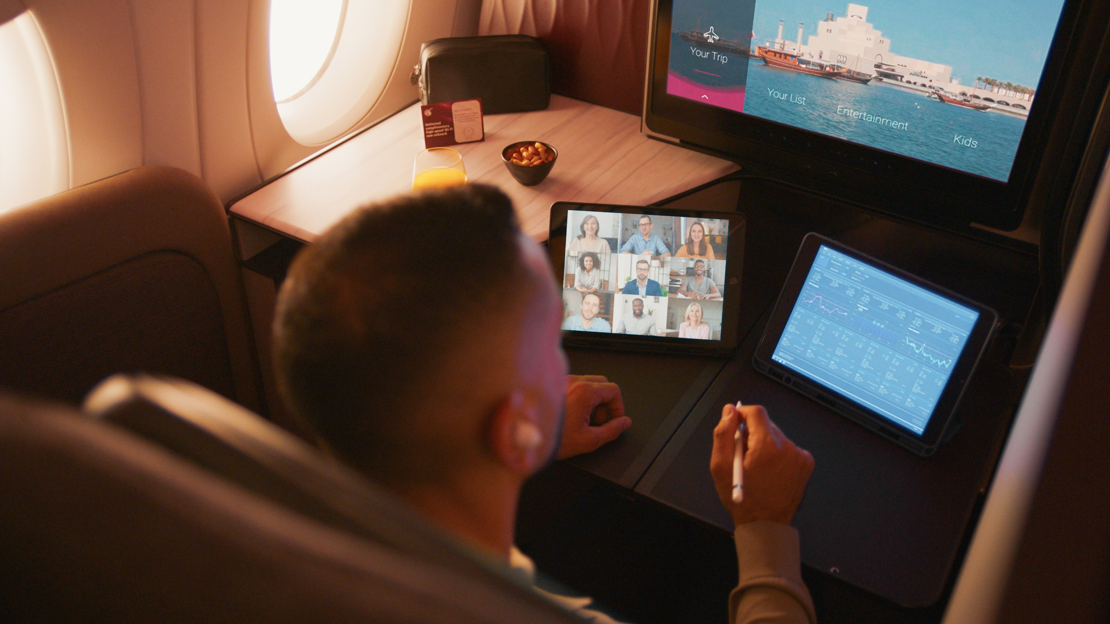 A man on a plane with two tablets
