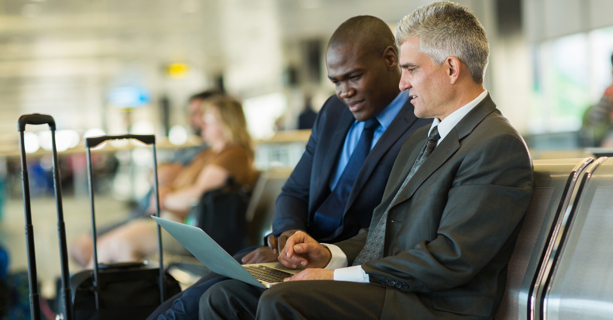 Two men in suits looking at a laptop screen