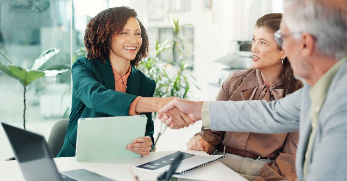 A woman and a man shaking hands in an office