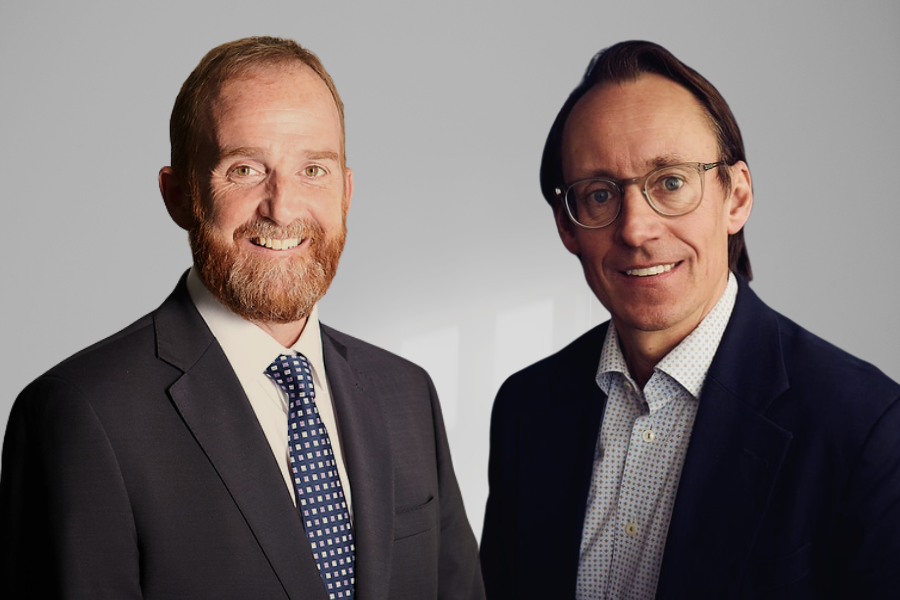 Two men in suits smiling