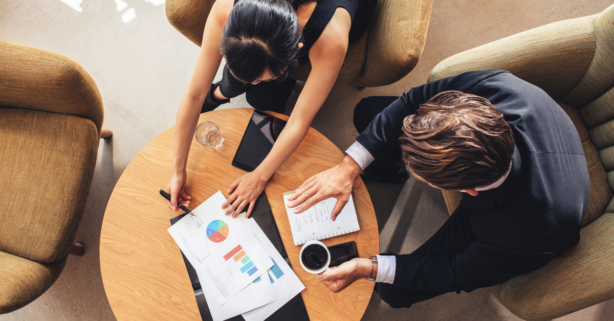 A top down view of two people at a meeting table