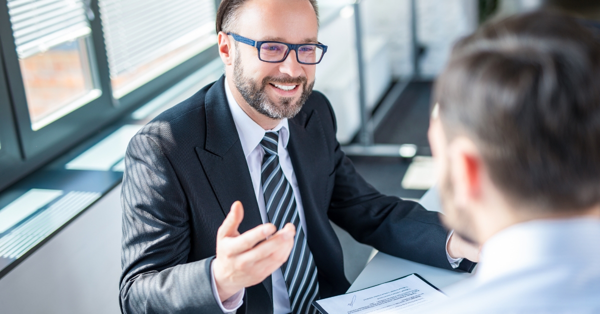 Two men in suites talking in an office