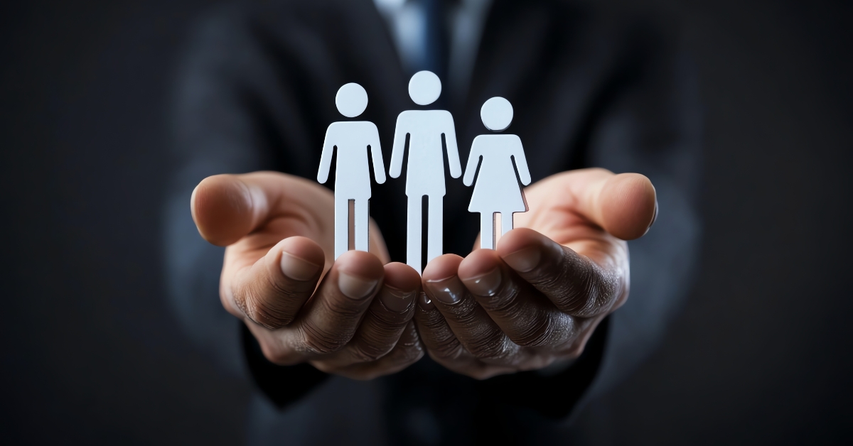 Hands holding a figurine of 3 people