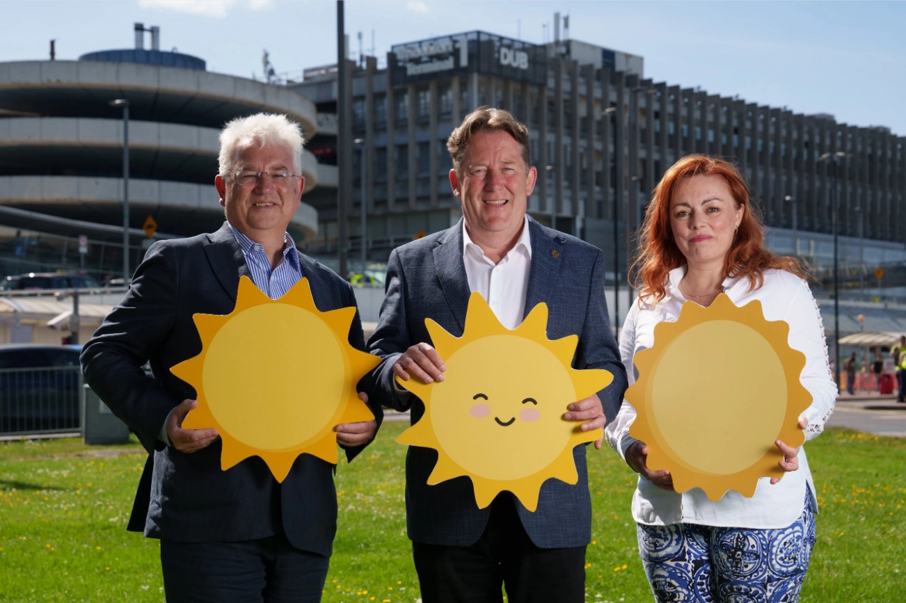 Three people holding sun cut outs