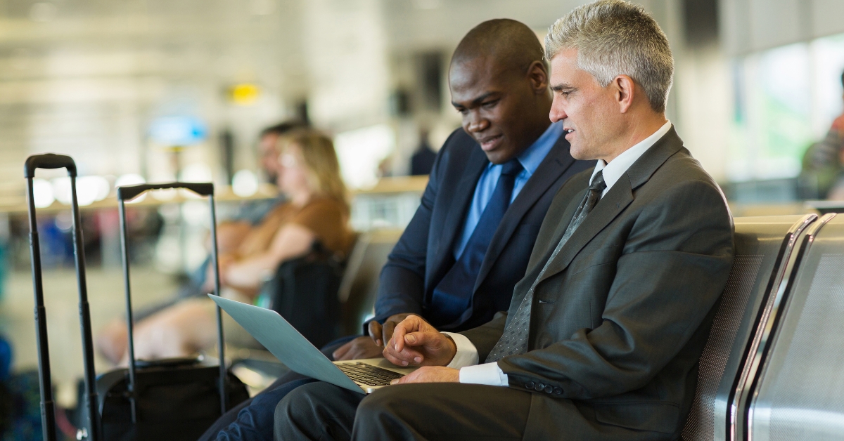 Two people sitting in business suits looking at a laptop