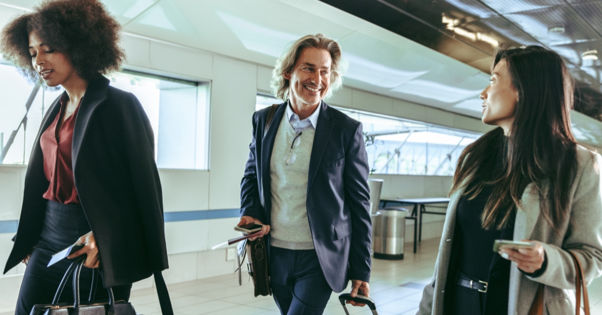 A group of people smiling and walking through an airport