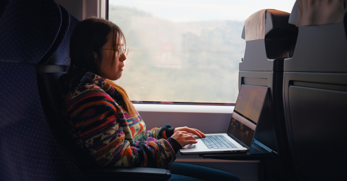 A woman working on a laptop on a train