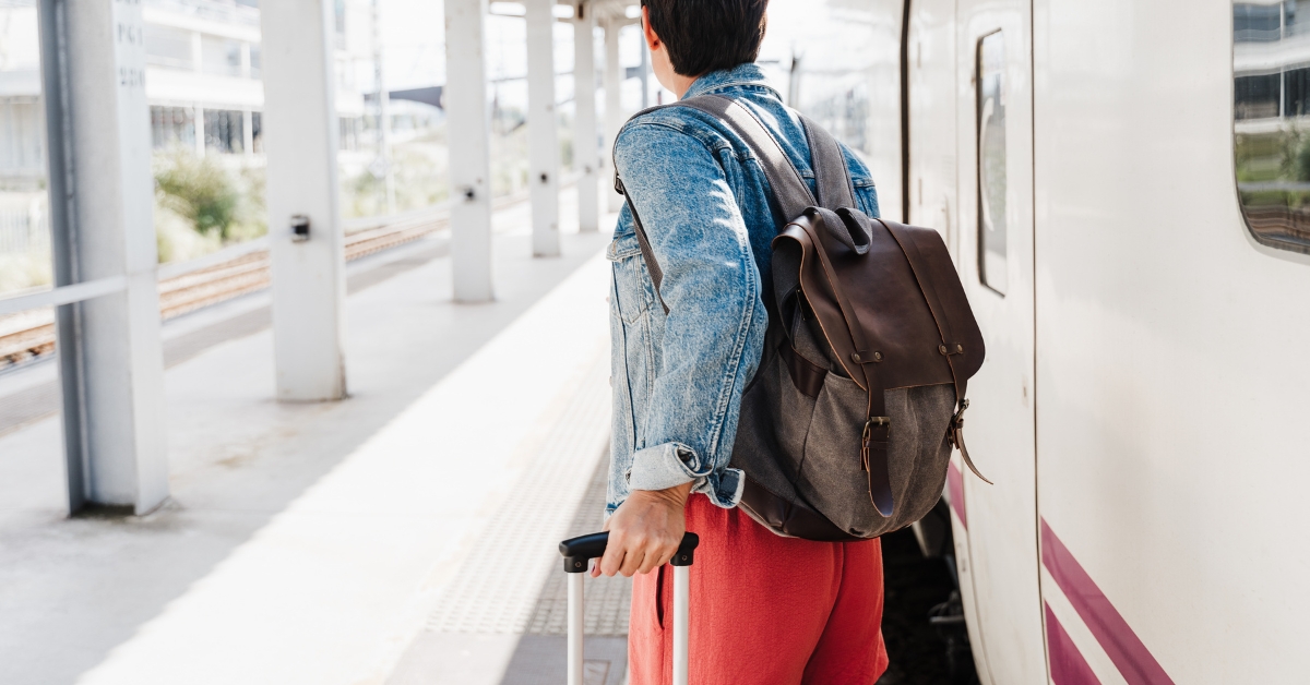 A person pulling a suitcase towards a train