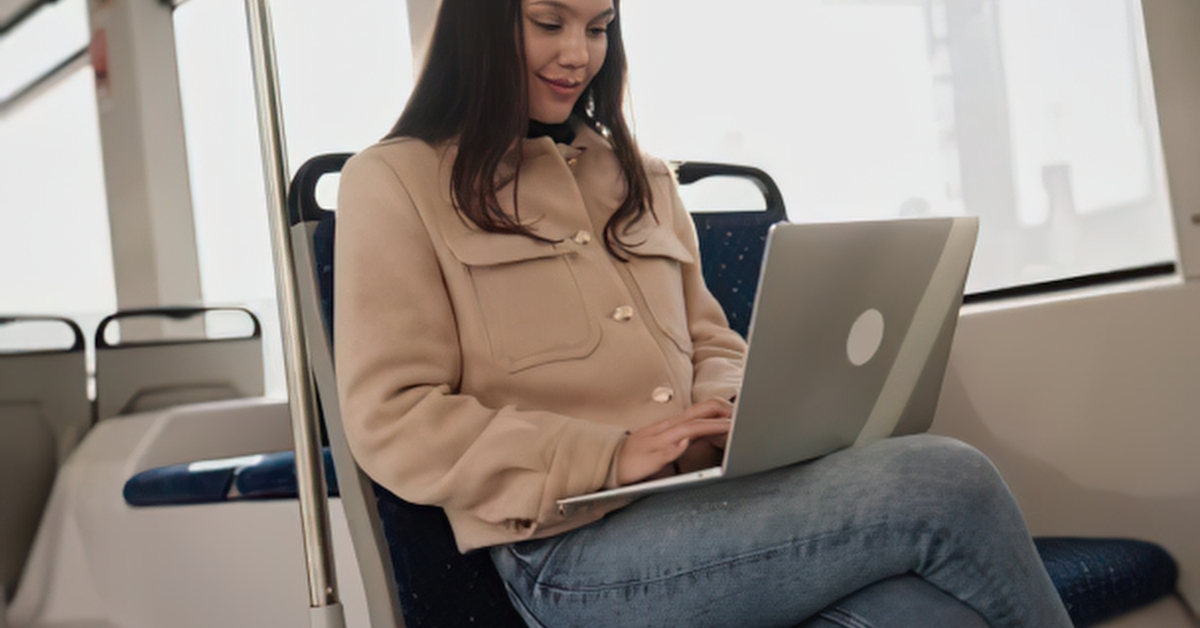 A woman working on a laptop on a train